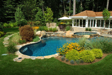 Inspiration for a large farmhouse backyard stone and custom-shaped hot tub remodel in Philadelphia
