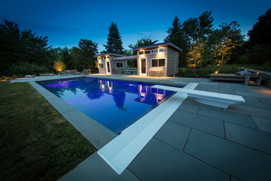 Modelo de casa de la piscina y piscina alargada minimalista de tamaño medio rectangular en patio trasero con adoquines de piedra natural