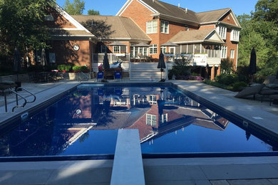 Large elegant backyard concrete paver and rectangular natural pool photo in Cedar Rapids