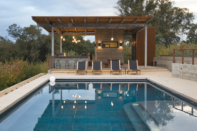 Пример оригинального дизайна: большой спортивный, прямоугольный бассейн на заднем дворе в стиле модернизм с зоной барбекю