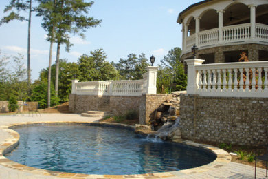 Modelo de piscina con fuente natural tradicional tipo riñón en patio trasero con adoquines de ladrillo