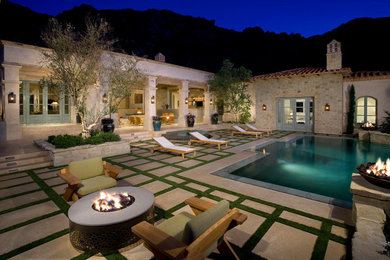 Example of a mid-sized tuscan courtyard concrete paver and custom-shaped pool design in Other