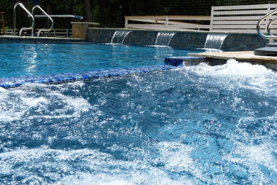 Modelo de piscinas y jacuzzis minimalistas grandes rectangulares en patio lateral con losas de hormigón