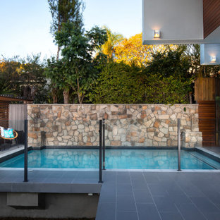 Mid-sized contemporary backyard rectangular pool in Brisbane with tile.