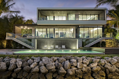Foto di una grande piscina monocorsia moderna rettangolare dietro casa con piastrelle