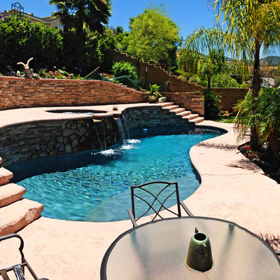 Pool - mid-sized mediterranean backyard stamped concrete and custom-shaped aboveground pool idea in Los Angeles