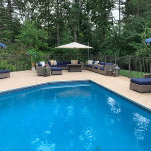 Immagine di una grande piscina chic personalizzata dietro casa con pedane
