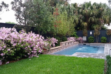 Example of a classic backyard stone and rectangular pool design in New Orleans