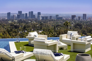 Photo of a large modern back rectangular infinity swimming pool in Los Angeles.