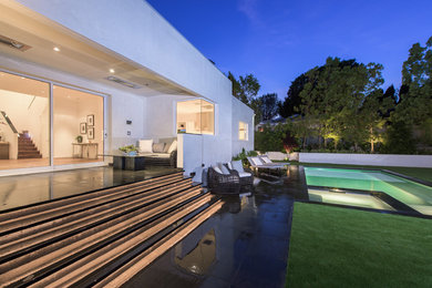 Imagen de piscinas y jacuzzis alargados minimalistas grandes rectangulares en patio trasero con adoquines de piedra natural