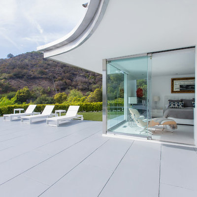 Mid-century modern backyard concrete and kidney-shaped pool photo in Los Angeles