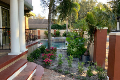 Diseño de piscinas y jacuzzis naturales modernos grandes a medida en patio trasero con adoquines de piedra natural