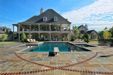 Foto di una piscina monocorsia tropicale rettangolare di medie dimensioni e dietro casa con una vasca idromassaggio e pavimentazioni in pietra naturale