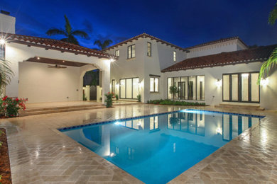 Ejemplo de casa de la piscina y piscina alargada mediterránea de tamaño medio rectangular en patio trasero con adoquines de hormigón