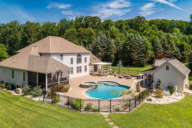Diseño de casa de la piscina y piscina tradicional grande a medida en patio trasero con adoquines de hormigón