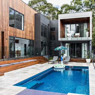 Photo of a large contemporary backyard rectangular pool in Wollongong with a hot tub.