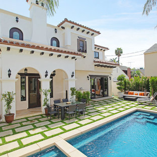 Photo of a mid-sized mediterranean backyard rectangular pool in Los Angeles with natural stone pavers.