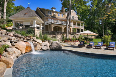 Foto de piscina con fuente natural clásica a medida en patio trasero con adoquines de piedra natural
