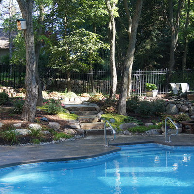 Mid-sized arts and crafts courtyard stamped concrete and custom-shaped aboveground pool photo in Detroit