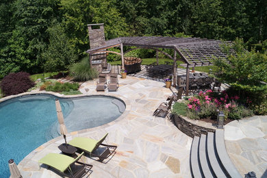 Large elegant backyard stone and custom-shaped pool photo in New York
