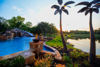 Foto di un'ampia piscina tropicale dietro casa