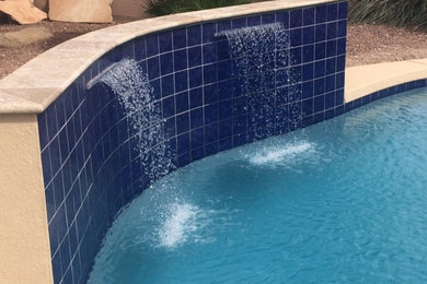 Ejemplo de piscina con fuente mediterránea de tamaño medio a medida en patio trasero con suelo de baldosas