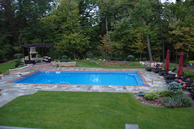 На фото: большой спортивный, прямоугольный бассейн на заднем дворе в классическом стиле с покрытием из каменной брусчатки и фонтаном