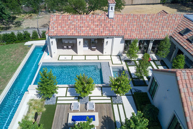 На фото: большой прямоугольный бассейн-инфинити на заднем дворе в стиле модернизм с покрытием из бетонных плит с