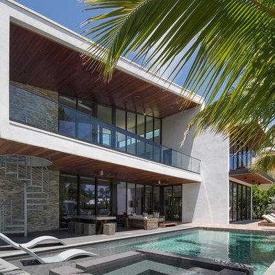 Large trendy backyard rectangular lap pool photo in Miami with decking