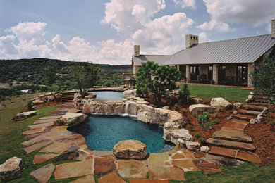 Пример оригинального дизайна: огромный естественный бассейн произвольной формы на заднем дворе в стиле рустика с фонтаном и покрытием из каменной брусчатки