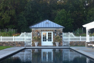 На фото: спортивный, прямоугольный бассейн среднего размера на заднем дворе в классическом стиле с домиком у бассейна и покрытием из плитки с