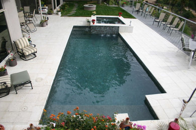 На фото: маленький спортивный, прямоугольный бассейн на заднем дворе в стиле модернизм с фонтаном и мощением тротуарной плиткой для на участке и в саду