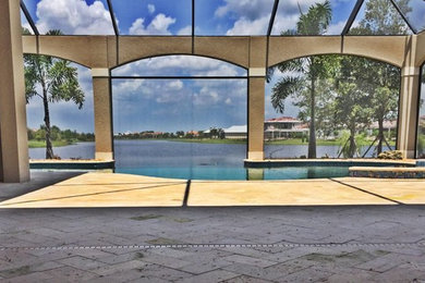 Mid-sized elegant backyard stone and custom-shaped infinity hot tub photo in Tampa