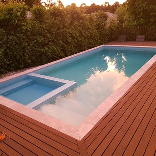 Immagine di una piscina contemporanea rettangolare di medie dimensioni e dietro casa con pedane