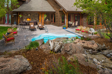 Ejemplo de piscina con fuente natural de estilo americano de tamaño medio tipo riñón en patio trasero con adoquines de piedra natural