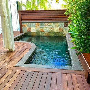 Esempio di una piccola piscina tropicale a "L" dietro casa con fontane e pedane