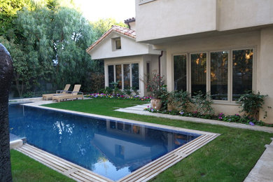 Foto de piscinas y jacuzzis infinitos mediterráneos grandes rectangulares en patio trasero con adoquines de piedra natural