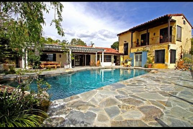 Imagen de piscinas y jacuzzis naturales mediterráneos grandes a medida en patio trasero con adoquines de piedra natural