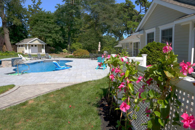 Example of a mid-sized classic backyard concrete paver and custom-shaped natural pool fountain design in New York