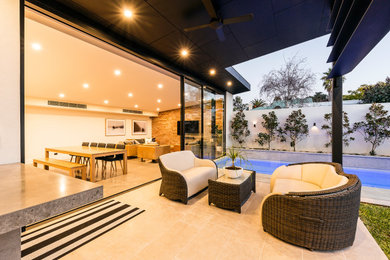Diseño de piscina actual de tamaño medio rectangular en patio trasero con adoquines de piedra natural