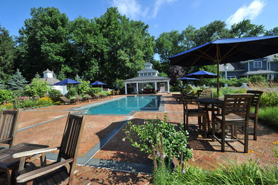 Mid-sized elegant backyard brick and rectangular lap pool photo in New York