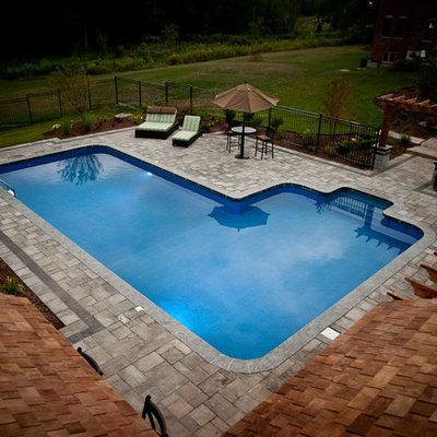 Mid-sized arts and crafts backyard concrete paver and rectangular natural pool house photo in Toronto