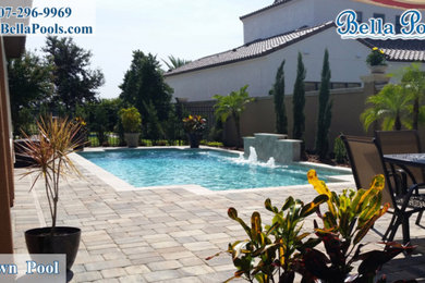 Inspiration for a large mediterranean backyard brick and custom-shaped lap pool fountain remodel in Orlando