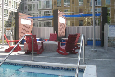 Modelo de piscina natural clásica renovada de tamaño medio rectangular en patio con losas de hormigón