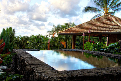 This is an example of a large world-inspired back rectangular above ground swimming pool in Hawaii with a pool house.