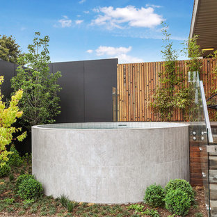 Idee per una piscina fuori terra contemporanea rotonda di medie dimensioni e dietro casa con pedane