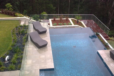 Idée de décoration pour une grande piscine naturelle et arrière design sur mesure.