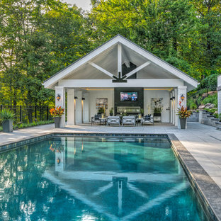 Modelo de casa de la piscina y piscina alargada, clásica renovada, grande, rectangular, en patio trasero, con adoquines de hormigón