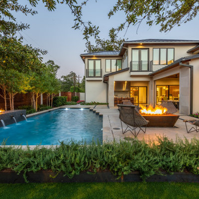 Example of a large trendy backyard concrete and rectangular lap pool fountain design in Dallas