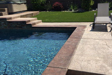 Ejemplo de piscina clásica renovada grande en patio trasero con adoquines de piedra natural
